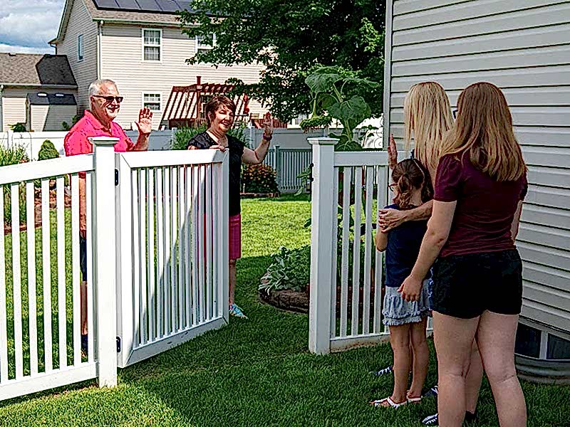 Refer a Friend Image Neighbors greeting each other by fence