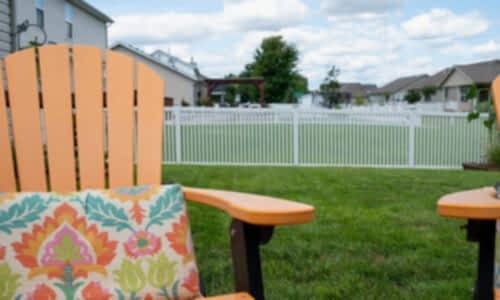 Fence-Deck-Depot-034-vinyl-fence-installati Backyard patio chair in foreground with fences in background